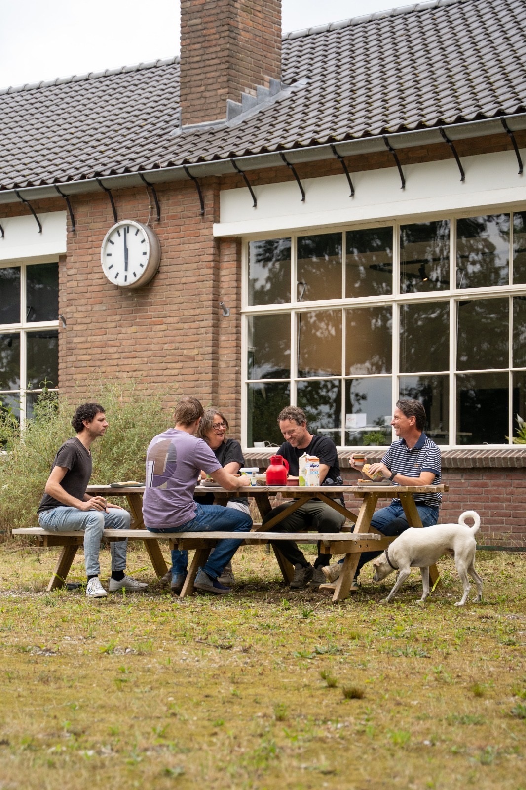 Het team van DOCS aan de picknicktafel voor het kantoor